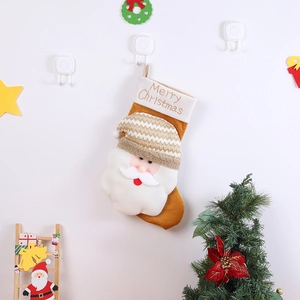 Gros plan du Père Noël en peluche sur une chaussette de Noël en tricot avec broderie