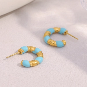 Detail of 18K gold-plated stainless steel C-shaped earrings with textured blue inlay