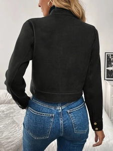 Detail of black suede short jacket featuring decorative gold metal buttons on cuffs
