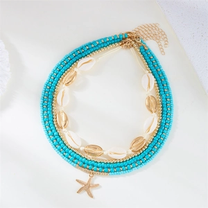 Close-up of layered necklace with blue beads, white shells and a gold starfish pendant