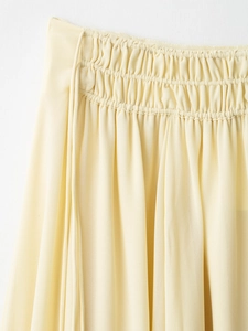 Detail of light yellow chiffon fabric with elastic smocking and delicate pleats