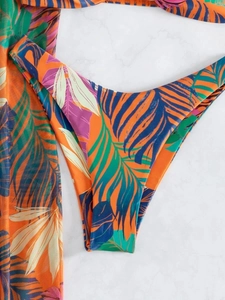 Macro detail of tropical palm leaf print bikini bottoms and mesh sarong fabric