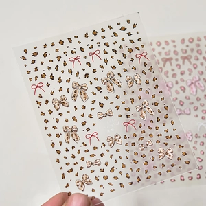 Nahaufnahme von ultradünnen Nagelstickern mit Leopardenmustern und Schleifenmotiven