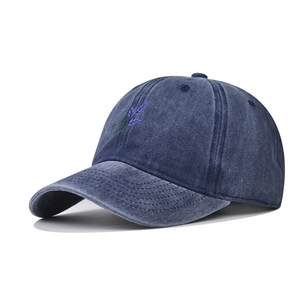 Close-up of violet lavender floral embroidery on a washed navy blue baseball cap