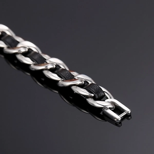 Détail du cuir noir tissé dans une chaîne cubaine en acier argenté avec reflet net