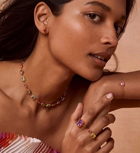 Detailed view of model wearing a gold jewelry set with colorful geometric crystals