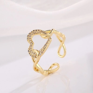Close-up of gold-plated heart ring with sparkling cubic zirconia and open adjustable band
