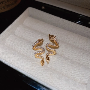 Elegant gold plated dragon snake stud earrings with zircon crystals in a beige jewelry box