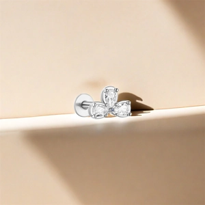 Macro view of 925 silver stud earring with three water-drop zircons on a beige stand