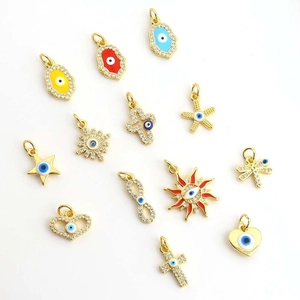 Detailed close-up of gold-plated evil eye charms with cubic zirconia on white background