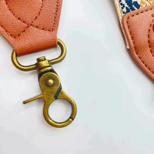 Detail of bronze lobster clasp and brown lychee grain leather on ethnic bag strap