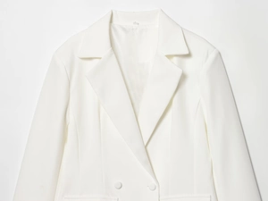 Détail de blazer blanc à double boutonnage montrant le revers et l'épaule