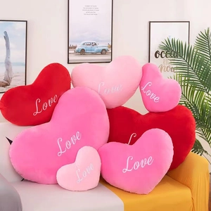 Herzförmige Plüschkissen in Rot und Rosa mit Love-Stickerei für die Wohndeko