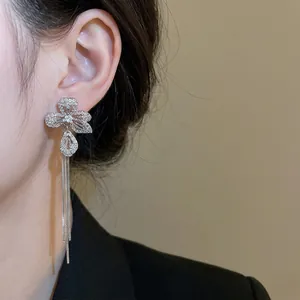 Silver flower tassel drop earrings with sparkling cubic zirconia on a female model