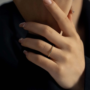 Close-up of minimalist gold S925 silver ring with zircon inlays on a model's finger