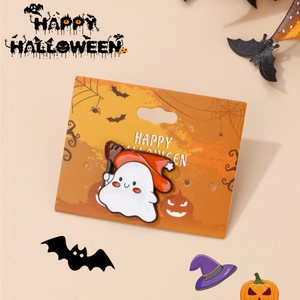 Cute ghost enamel pin with red wizard hat on a decorative Halloween display card