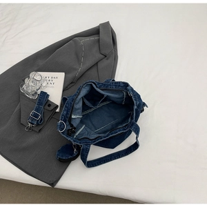 Detail view of denim tote bag interior with inner pocket and matching small coin pouch