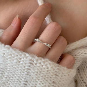 Close-up of 925 sterling silver bow ring on finger with soft knit sweater background
