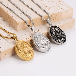 Vintage religious relief pendant necklaces in gold, silver, and black on travertine