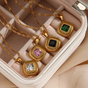 Detail of vintage square zircon pendants with sunburst patterns in four distinct colors