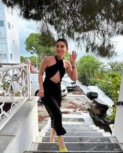 Outdoor shot of a black halter neck dress with backless tie detail on a model