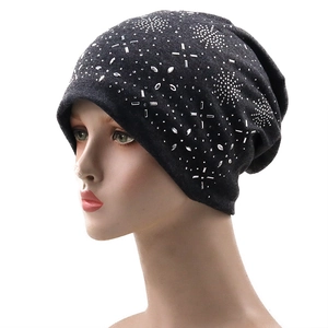 Detail of dark grey knit beanie featuring shimmering silver rhinestone snowflake patterns