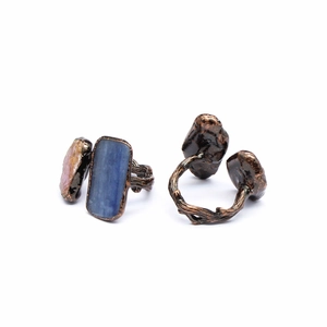Detail of vintage bronze branch rings with rectangular blue stone and pink crystal