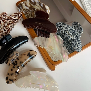 Flat lay of diverse French handmade acetate claw clips in tortoiseshell and shell patterns
