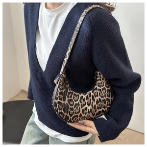 Model wearing a retro leopard print crescent shoulder bag with dark blue cardigan