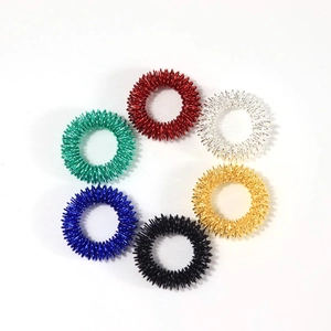Close-up of six colorful metal spring finger massage rings on white background