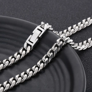 Macro shot of silver titanium steel Cuban link chain with a square clasp closure