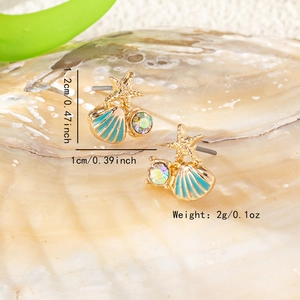 Elegant gold starfish shell earrings with blue enamel and rhinestone on a natural shell
