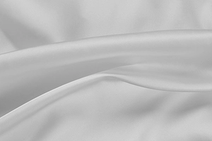 Detail shot of luxurious white satin fabric showing soft texture and premium silk gloss
