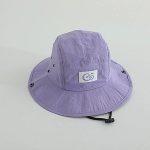 Détail du chapeau de soleil violet enfant montrant l'oeillet et le patch en tissu GO