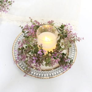 Top view of violet eucalyptus candle ring around glass holder on patterned plate