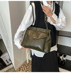 Dettaglio della borsa tote verde oliva scuro con chiusura a rotazione e tracolla a catena