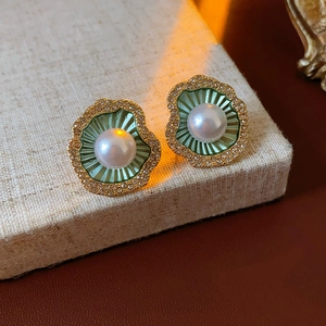 Détail macro de boucles d'oreilles coquillage vintage avec texture verte et perle