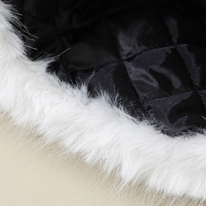 Détail de la bordure en fourrure de renard blanc et de la doublure matelassée noire d'hiver.