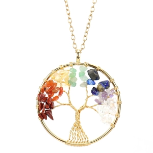 Close-up of handmade gold wire-wrapped Tree of Life pendant with natural chakra crystals