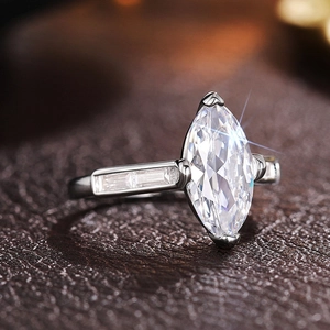 Macro shot of marquise-cut zircon ring with side baguette stones on leather background