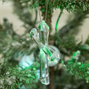 Clear acrylic Christmas cross pendant with snowflake design hanging on a festive tree