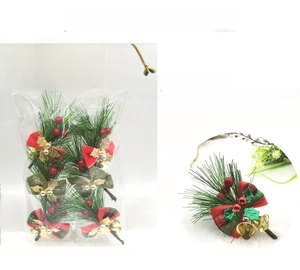 Detail showing artificial pine needles with red berries, bows and bells for Christmas decor