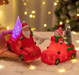 Close-up of lighted Christmas car decoration with Santa Claus and glowing Xmas tree