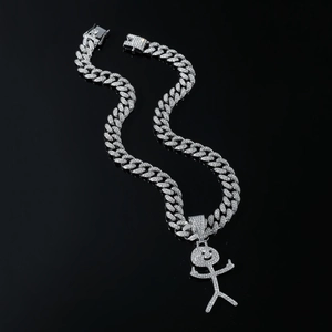 Macro shot of a silver Cuban chain with a diamond-encrusted smiling stickman pendant