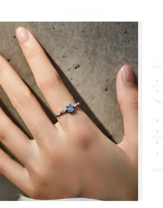 Detailed view of an S925 silver ring featuring a blue oval gem and marquise side stones