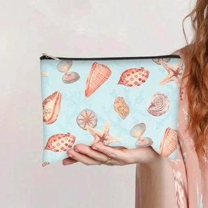 Détail d'une trousse de maquillage en toile avec des coquillages et une fermeture zippée