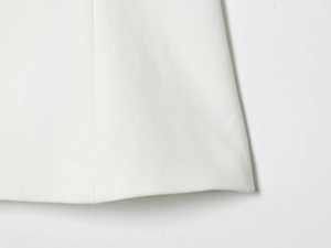 Vue macro détaillée du tissu blanc à armure toile et de la couture soignée de l'ourlet du bas