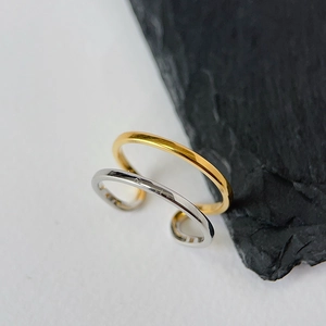 Detail view of two-tone gold and silver layered ring on a black stone slab