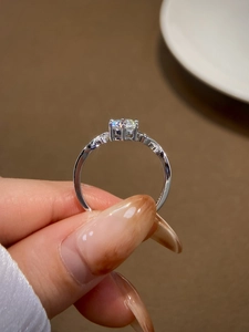 Macro view of a classic six-prong moissanite ring with a brilliant round cut stone