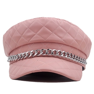 Detail of pink quilted leather newsboy hat featuring a chunky silver metal chain strap